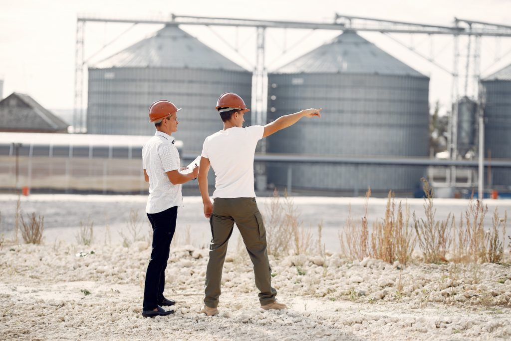 engineers-helmets-standing-by-factory